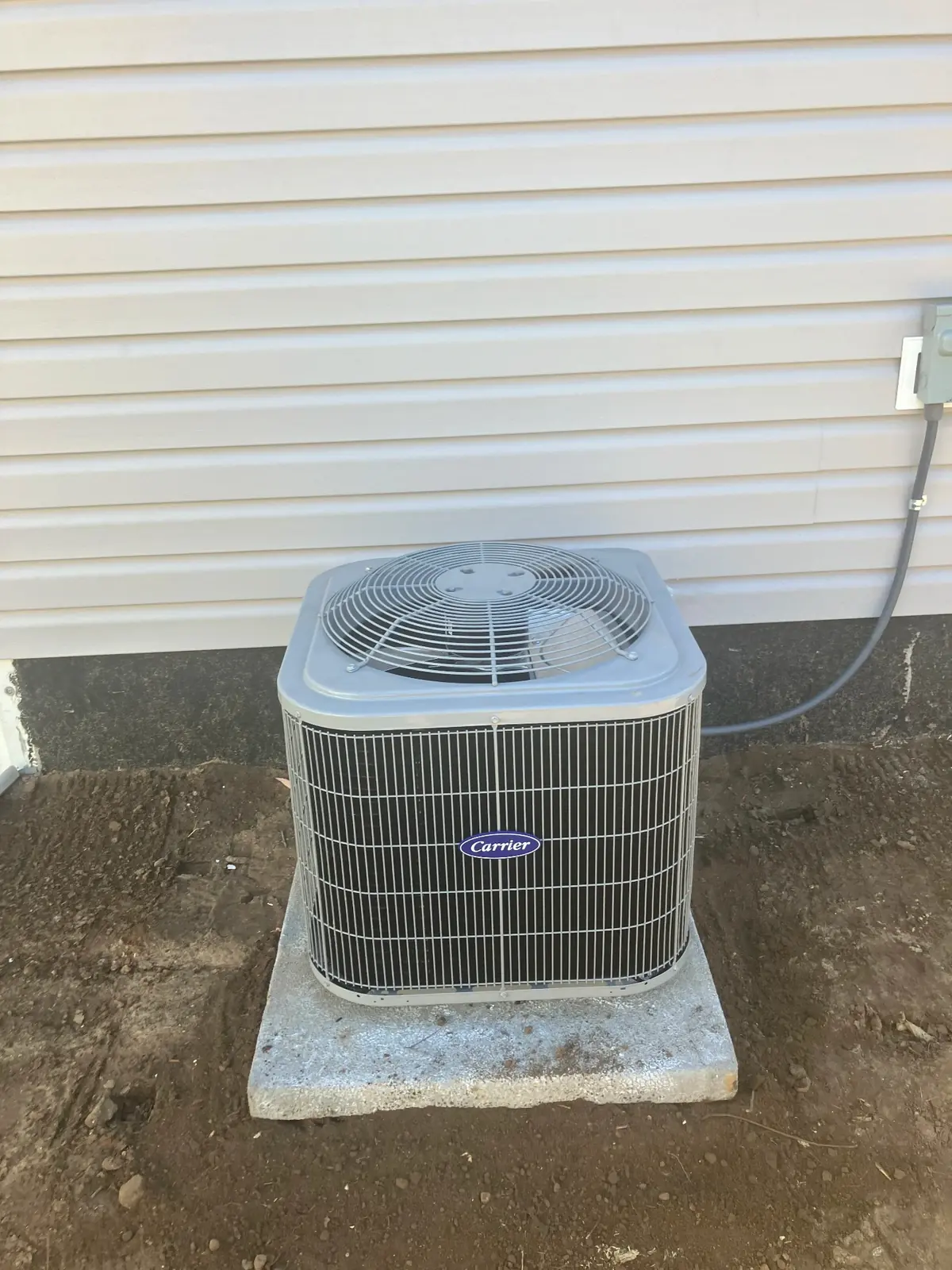 Carrier heat pump system installed on residential property showing professional installation with proper electrical connections