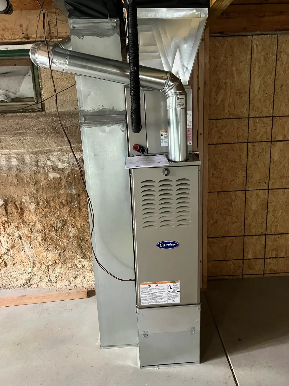Expert Furnace Installation - High Efficiency Carrier System Professional Carrier furnace installation in basement showing proper installation techniques and clean ductwork connections