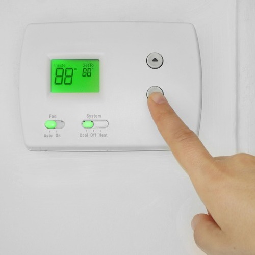 close-up of a thermostat being adjusted