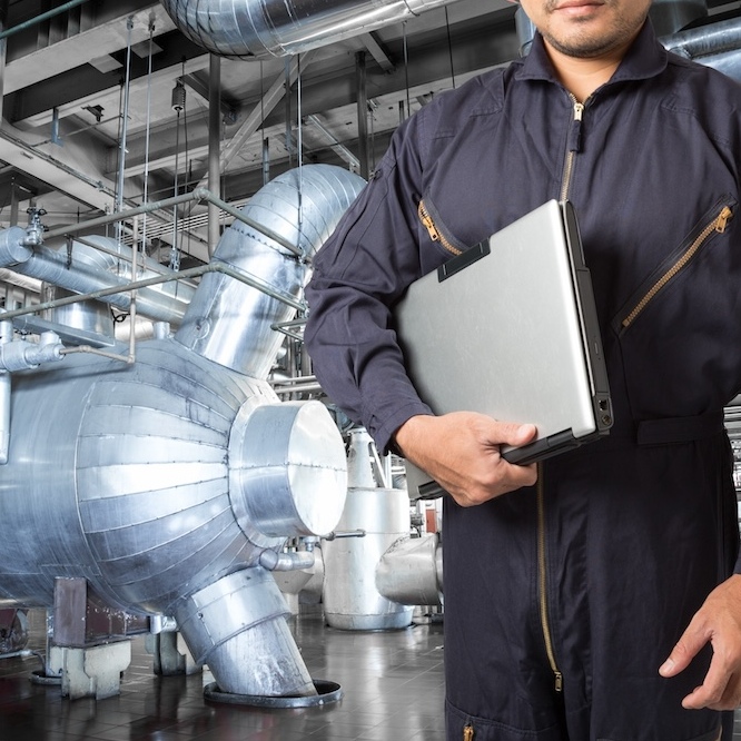 An HVAC technician is holding a clipboard.